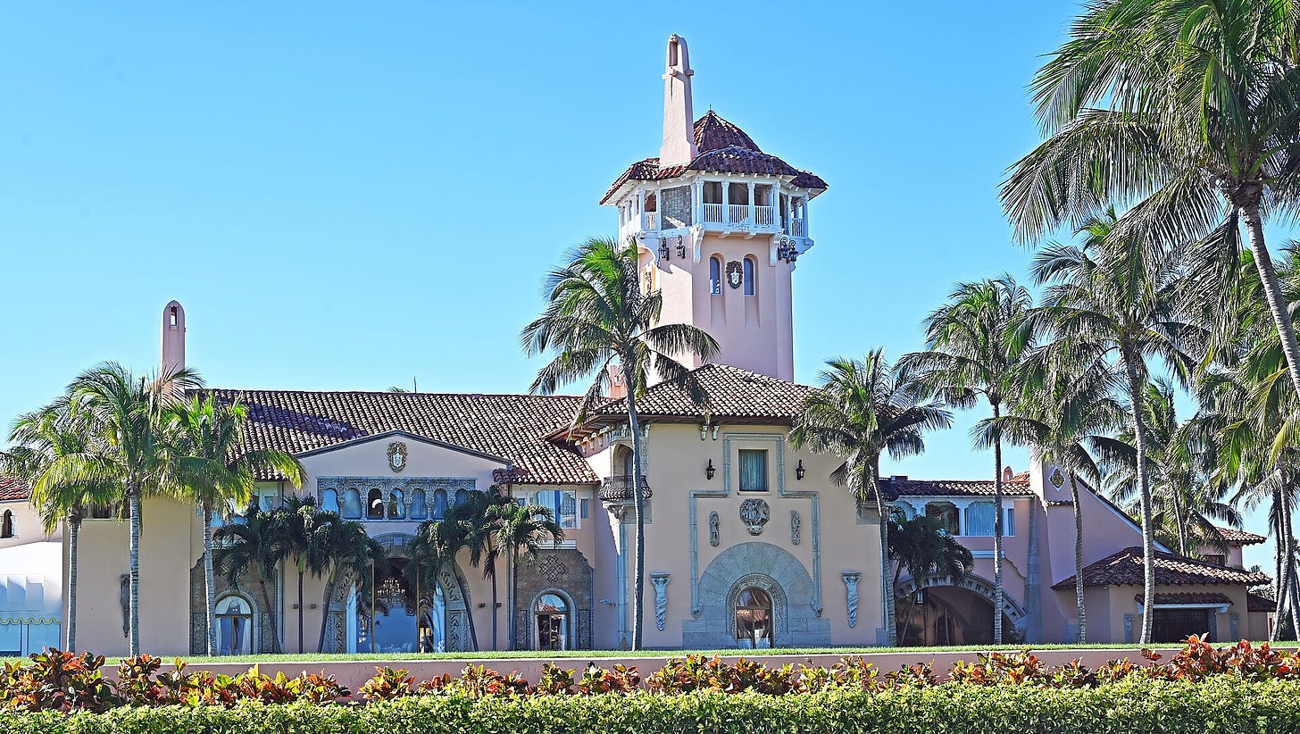 a large building infront of blue sky, surrounded by palm trees