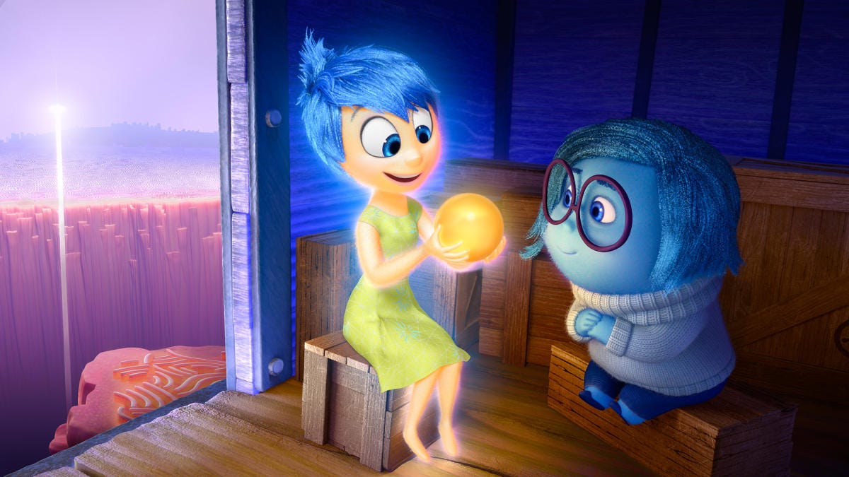 From Inside Out, Joy and Sadness sit on the train of thought, looking at a core memory ball.