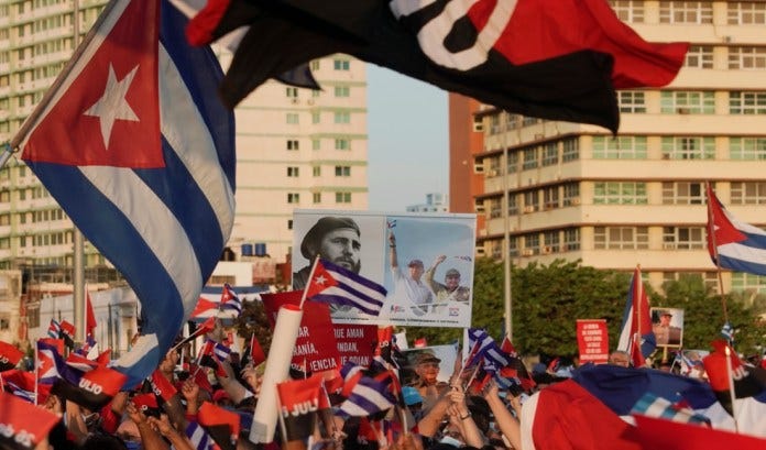 People carry a poster with photographs of Cuba's late President Fidel Castro, Cuba's President and First Secretary of the Communist Party Miguel Diaz-Canel and Cuba's former President and First Secretary of the Communist Party Raul Castro during a rally in Havana, Cuba, July 17, 2021. REUTERS/Alexandre Meneghini