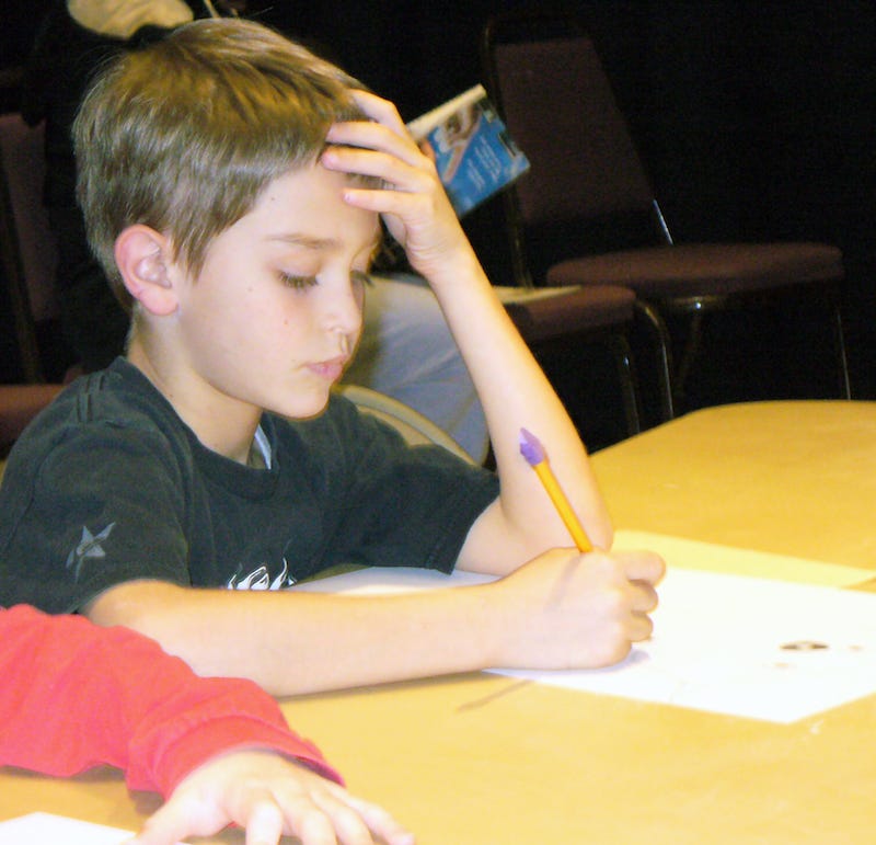 Photo by Sherry Killam Arts of a young boy focused on writing.