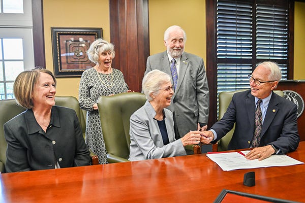 Alabama Nurses Foundation Director Dr. John Ziegler passes the pen to Dr. Brenda Riley to formalize a $50,000 endowed scholarship for Nursing. (TROY photo/JOEY MEREDITH)