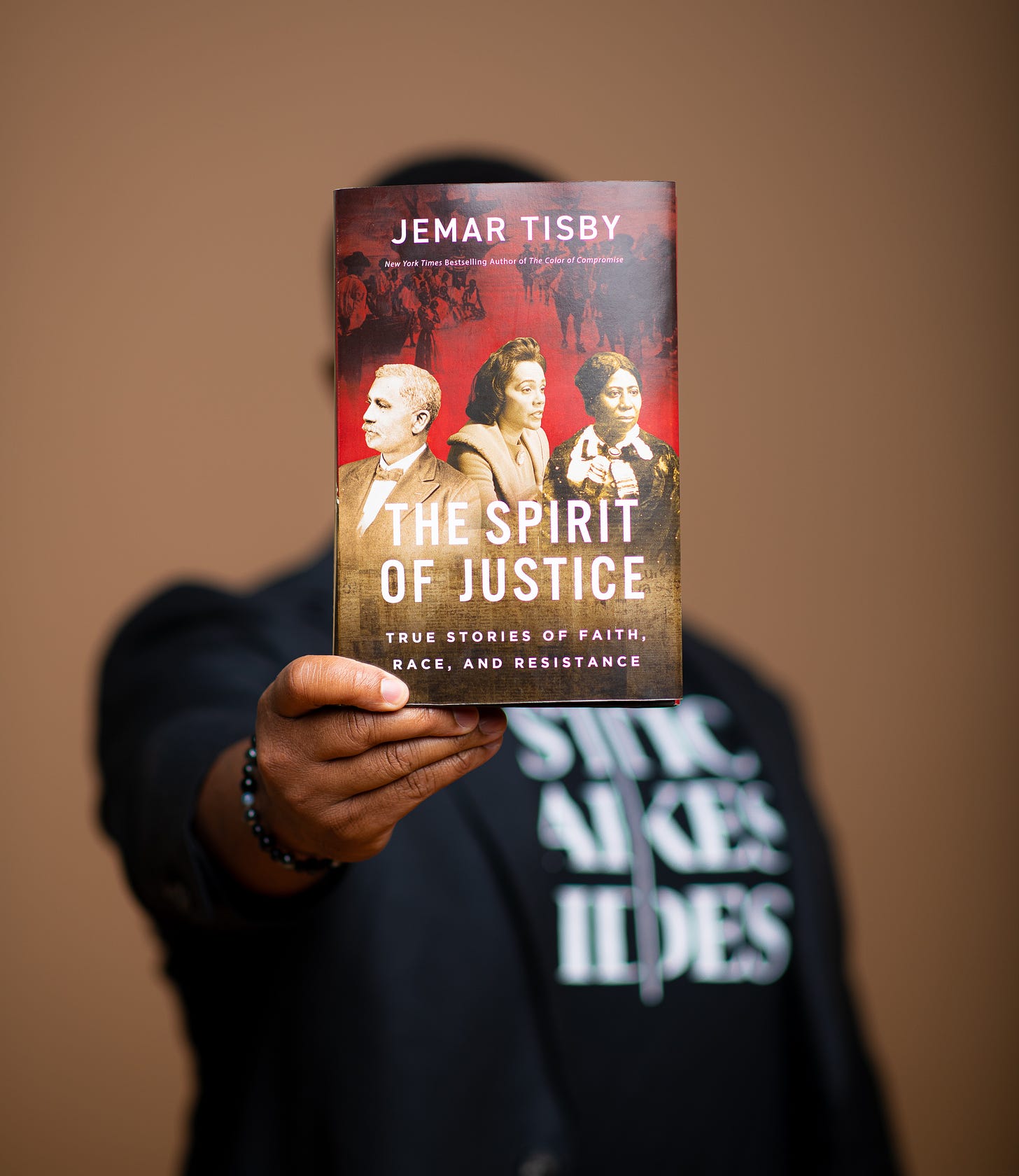 photo of me holding the spirit of justice book with one hand 