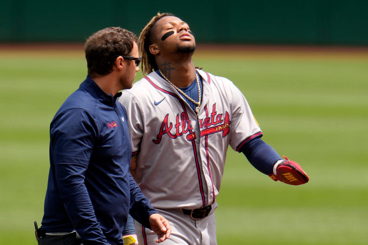 Ronald Acuña Jr. limps off the field with a trainer after tearing his ACL. (AP Photo/Gene J. Puskar)