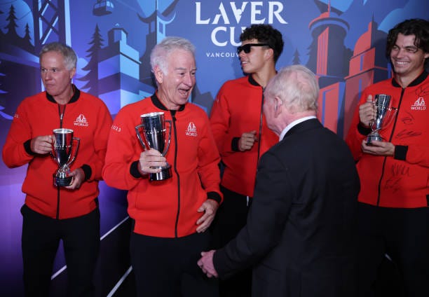 Rod Laver presents Captain John McEnroe of Team World with a mini Laver Cup trophy following their win over Team Europe during day three of the Laver...