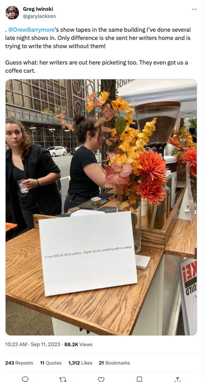 Tweet from Greg Iwinski. Picture: striking writers next to coffee cart with sign saying from drew WGA writers, thank you for picketing with us today, text: .  @DrewBarrymore ’s show tapes in the same building I’ve done several late night shows in. Only difference is she sent her writers home and is trying to write the show without them!  Guess what: her writers are out here picketing too. They even got us a coffee cart.