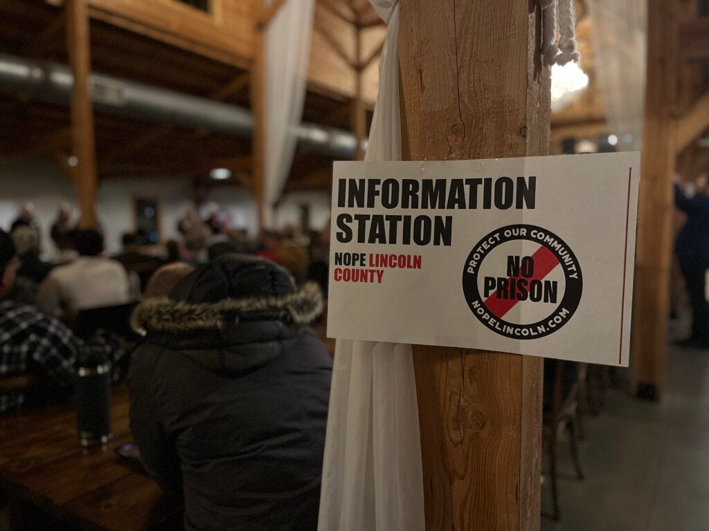 A sign opposing the proposed prison site in Lincoln County, SD, as seen at a community meeting in Harrisburg, SD on Dec. 21, 2023. (Josh Haiar/South Dakota Searchlight)