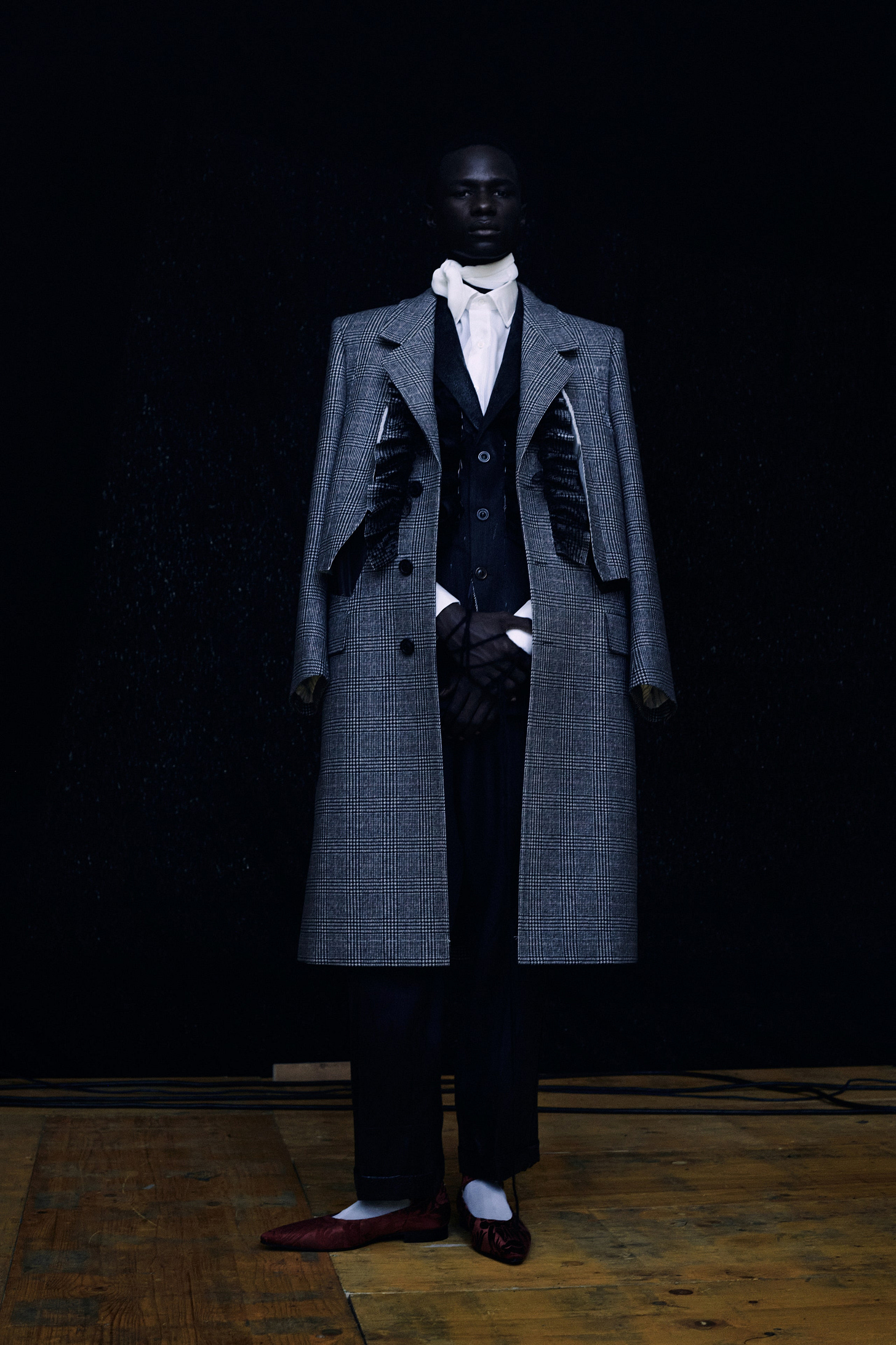 Image may contain Clothing Apparel Overcoat Coat Suit Trench Coat Human Person Shoe Footwear and Tuxedo