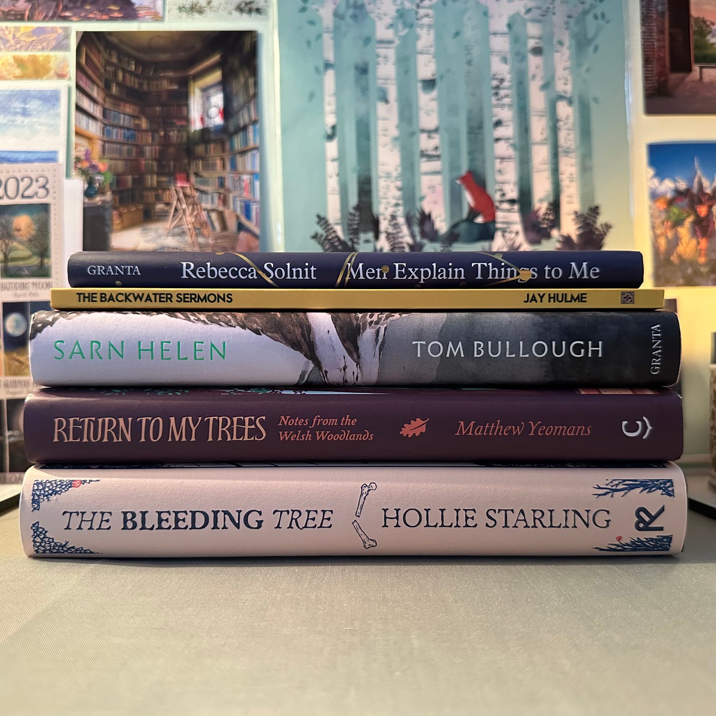 Pile of books from top to bottom: Rebecca Solnit Men Explain Things to Me, Jay Hulme's The Backwater Sermons, Tom Bullough's Sarn Helen, Matthew Yeoman's Return to my Trees, Hollie Starling's The Bleeding Tree