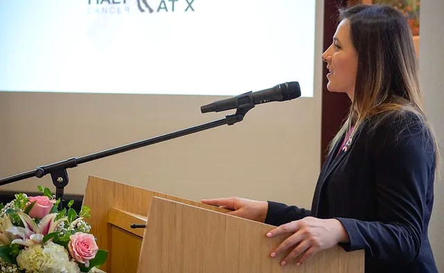 woman in dark blue suit at podium