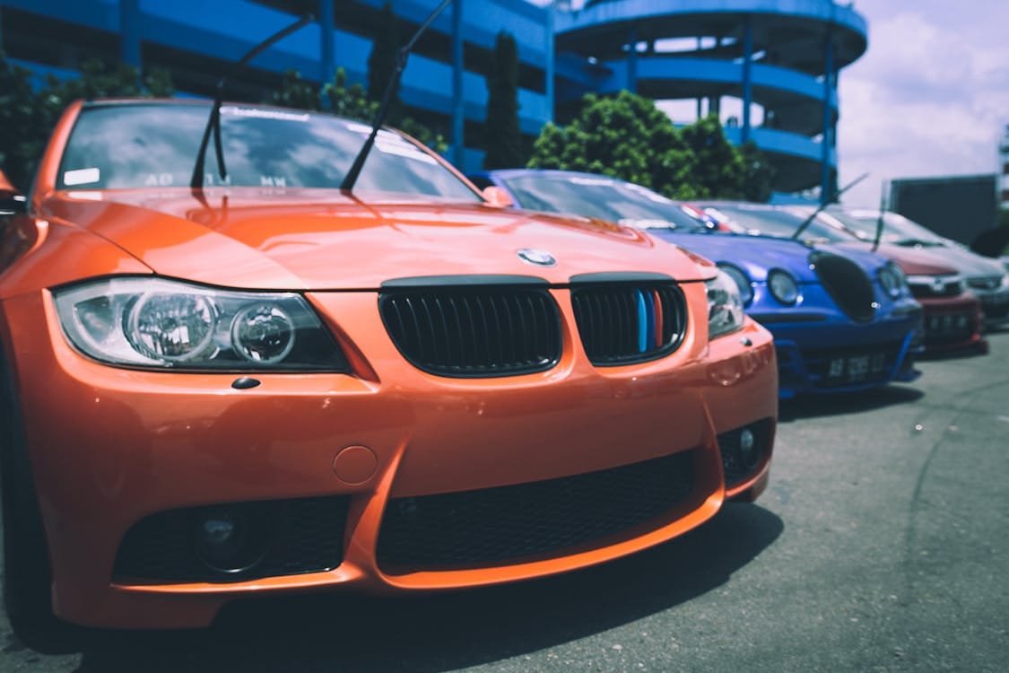 Free Orange Bmw Car Beside Blue Bugatti Car Stock Photo