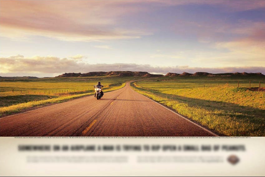 Mockup of Harley-Davidson print ad depicting motorbike and open road with headline blurred out