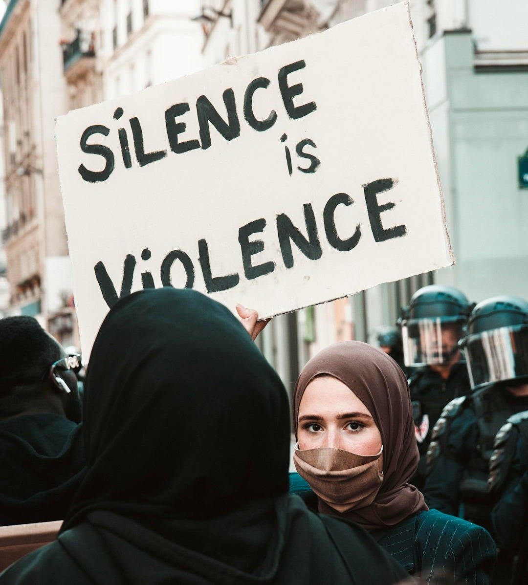 woman in black hijab holding white and black printed board woman in black hijab holding white and black printed board