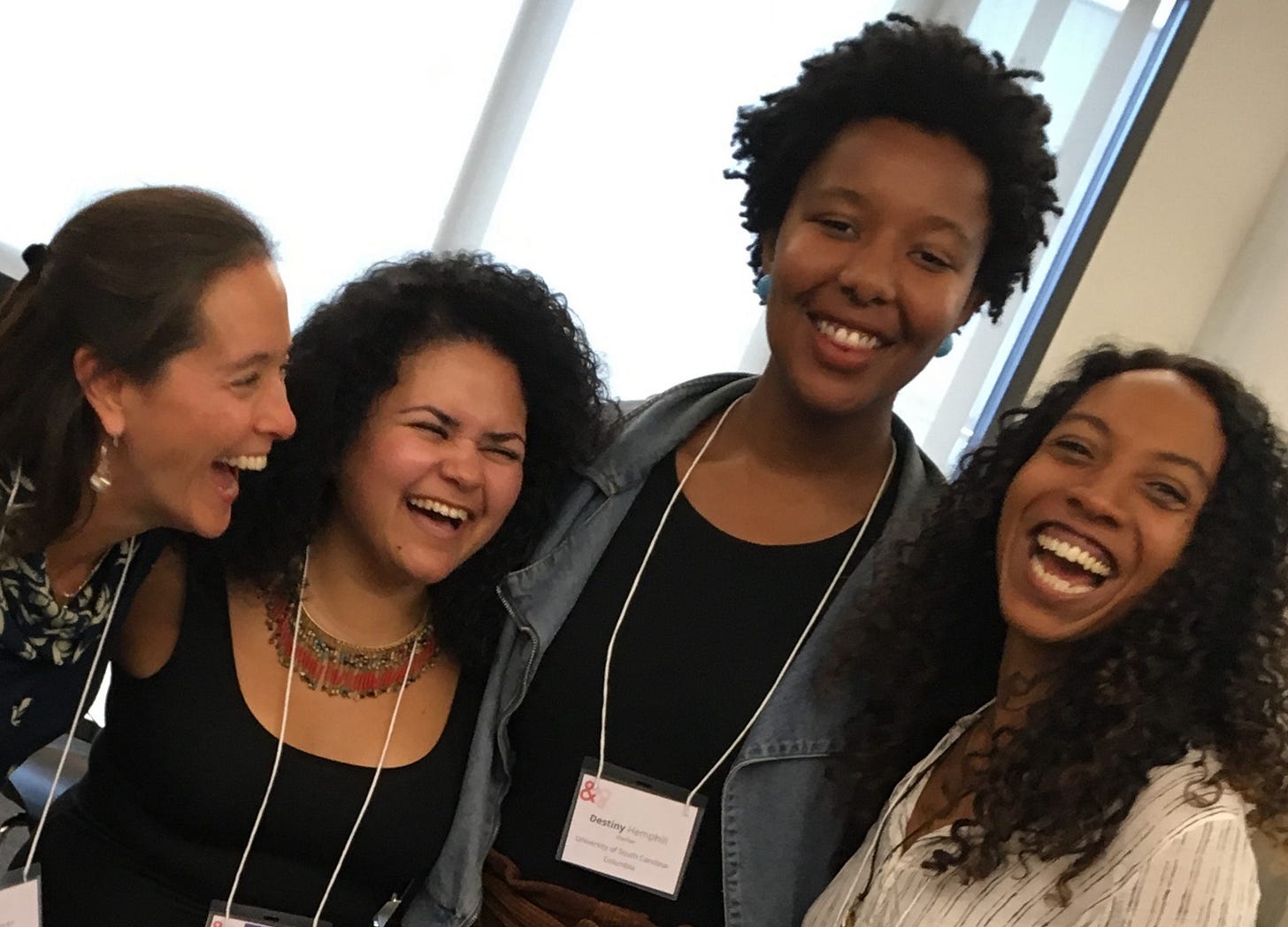 A quick snapshot of four people, laughing with mouths open.