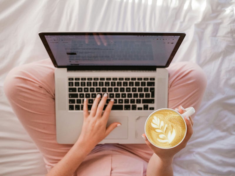 Person working with a laptop and a coffee cup. Person working with a laptop and a coffee cup.