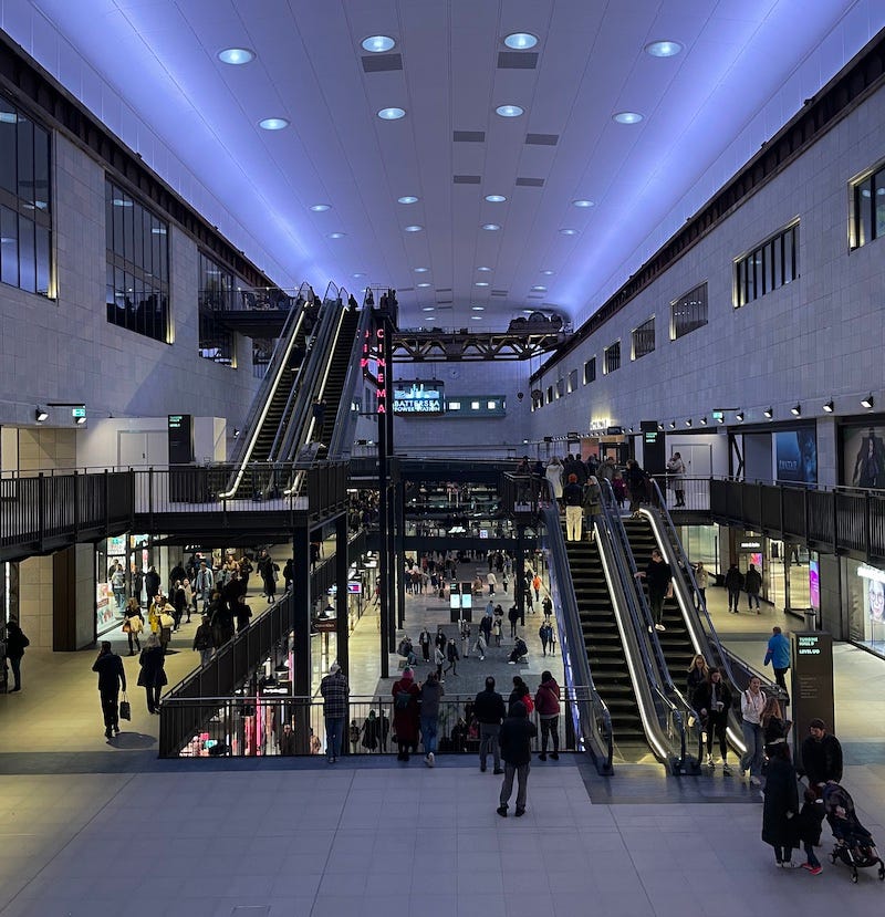 The interior of the Battersea power station shopping mall, which has a cinema, some escalators and kind of bluish lighting
