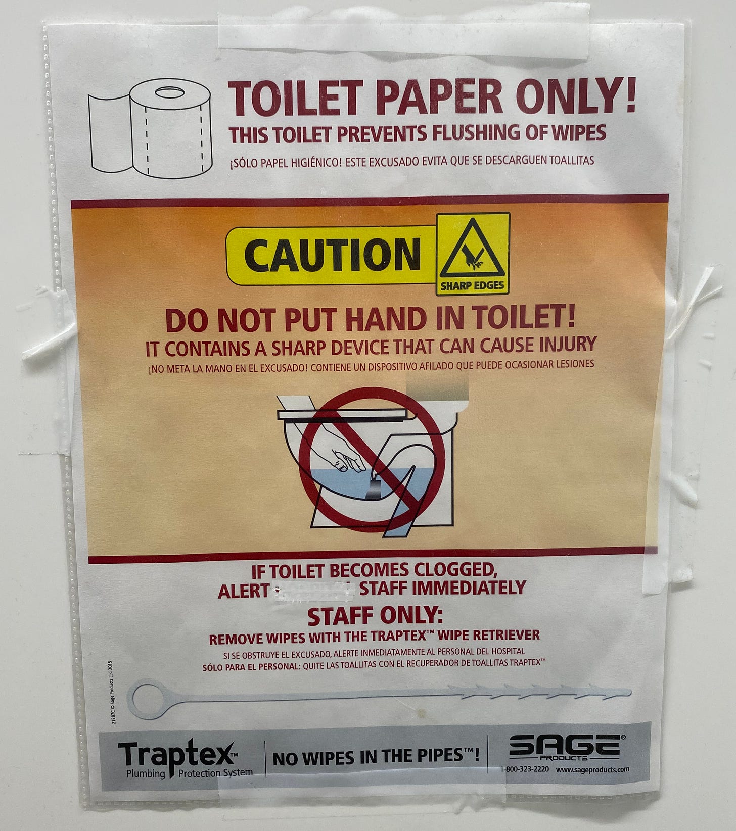 A paper sign taped to a wall warning you not to stick your hand in the toilet because it contains a sharp device.