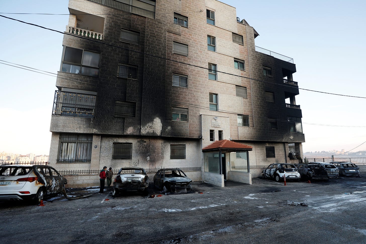 Damaged cars and burnt building show the aftermath of Israeli settler arson attacks in the West Bank city of al-Bireh, 4 November, 2024 (Reuters/Mohammed Torokman)