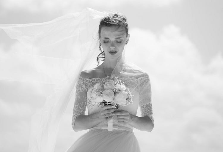 Bride with bouquet, in black and white photo.