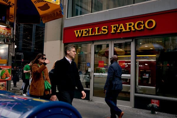 Pedestrians walk past a Wells Fargo branch in New York.