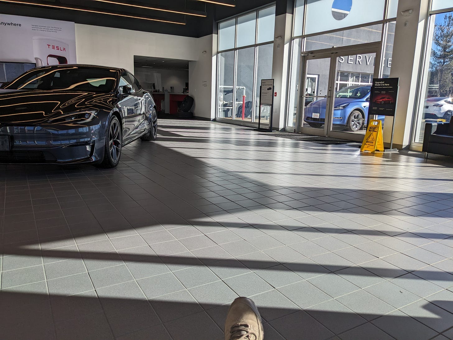 My view of the inside of a Tesla service station waiting room
