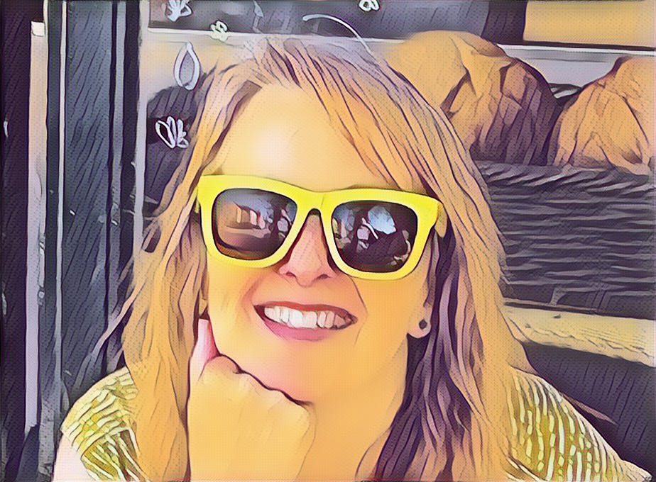 Head and shoulders stylised photo of Jane, a white middle aged woman with light brown shoulder length hair, wearing yellow sunglasses, outside a coffee shop window, looking happy.