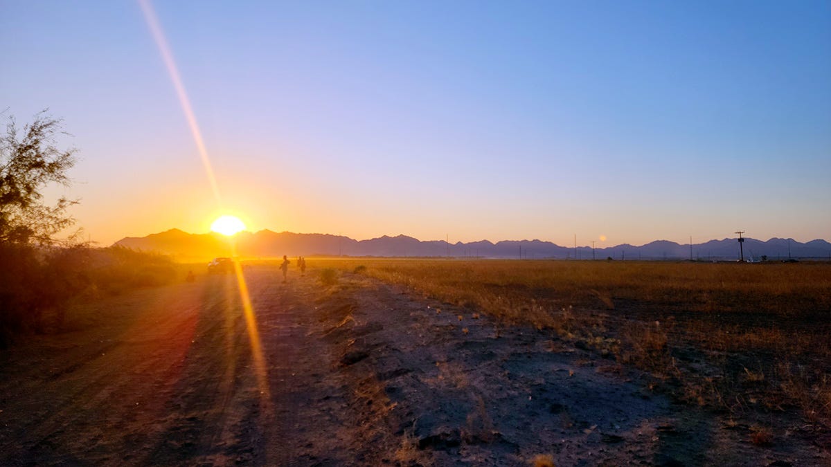 Sunrise in a field with hunters. 