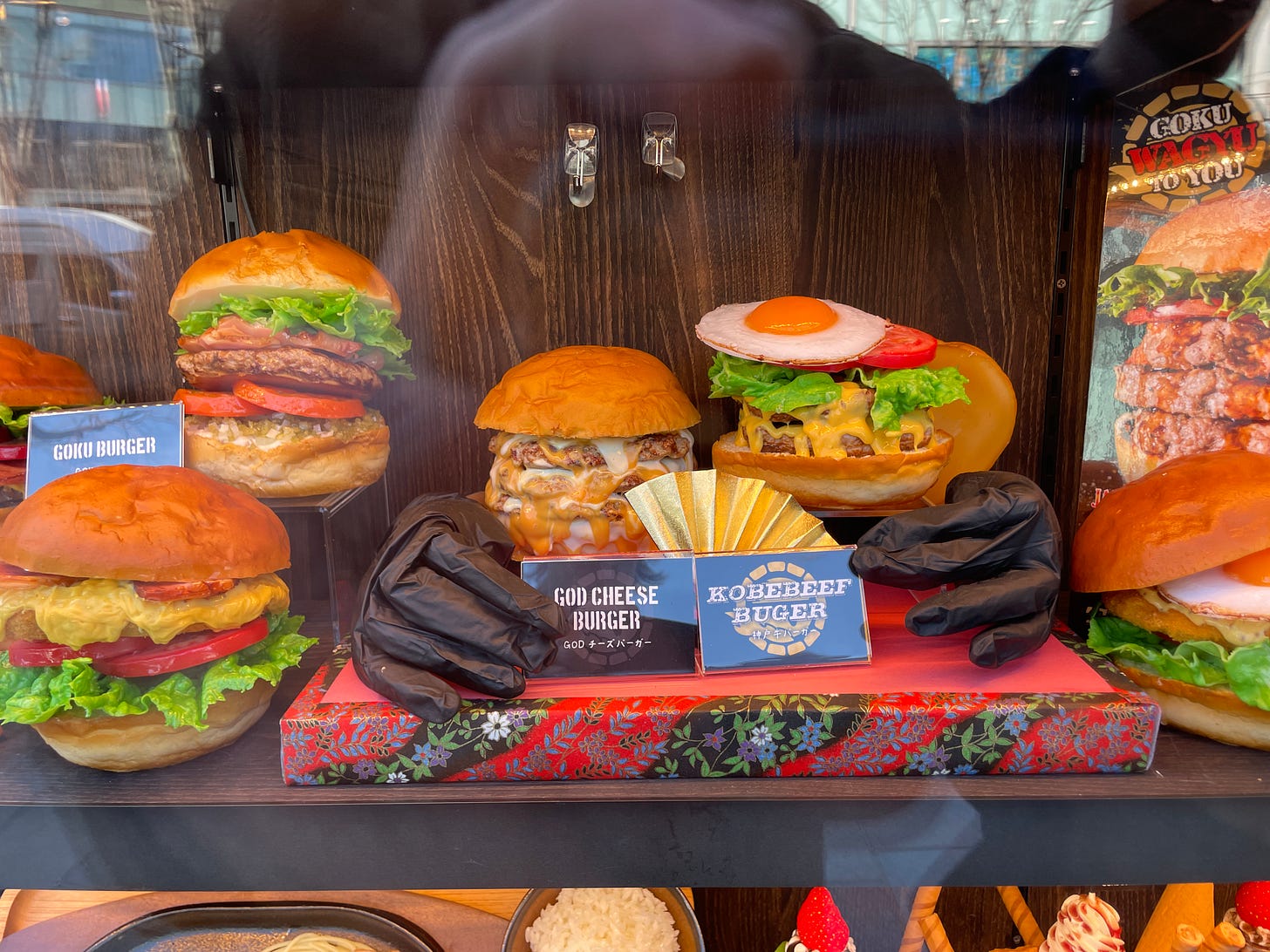 A display cabinet of models of various decadent cheeseburgers, seen in Japan.