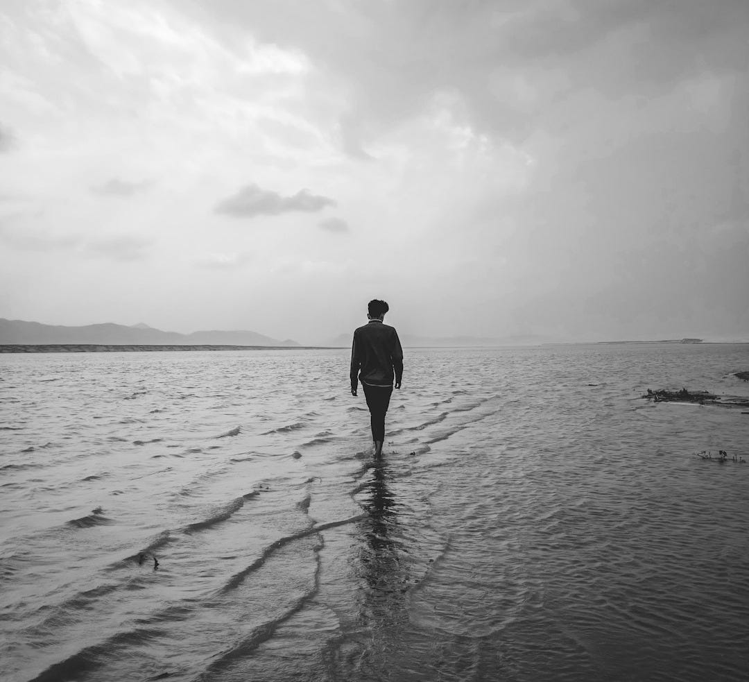 man in black jacket standing on the beach man in black jacket standing on the beach