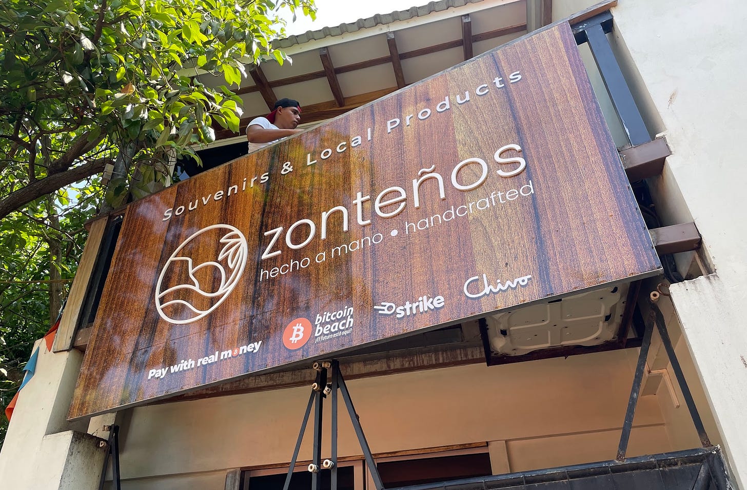 A sign for a handicrafts and souvenir store in El Zonte offers a range of cryptocurrency methods for payments — including “with real money”, with the “o” as the Bitcoin logo.