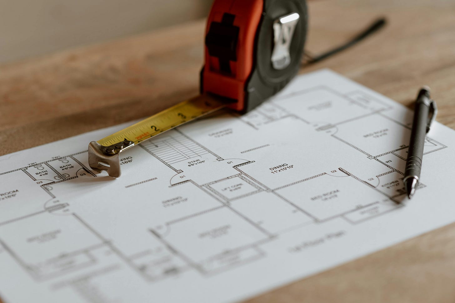 Paper floorplan with pen and tape measure.