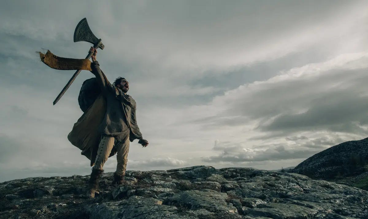 Sir Gawain (Dev Patel) hoists the Green Knight's mighty battle axe, in the 2021 film "The Green Knight." (A24) Sir Gawain (Dev Patel) hoists the Green Knight's mighty battle axe, in the 2021 film "The Green Knight." (A24)
