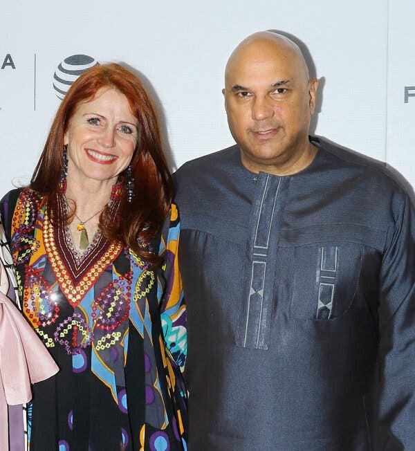 Jodie Evans, in a bright dress, and Neville Roy Singham, in an indigo shirt with no collar.