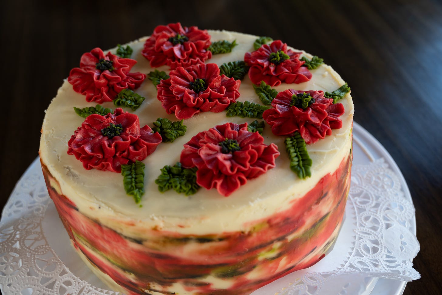a cake decorated with icing and icing poppy flowers on the top