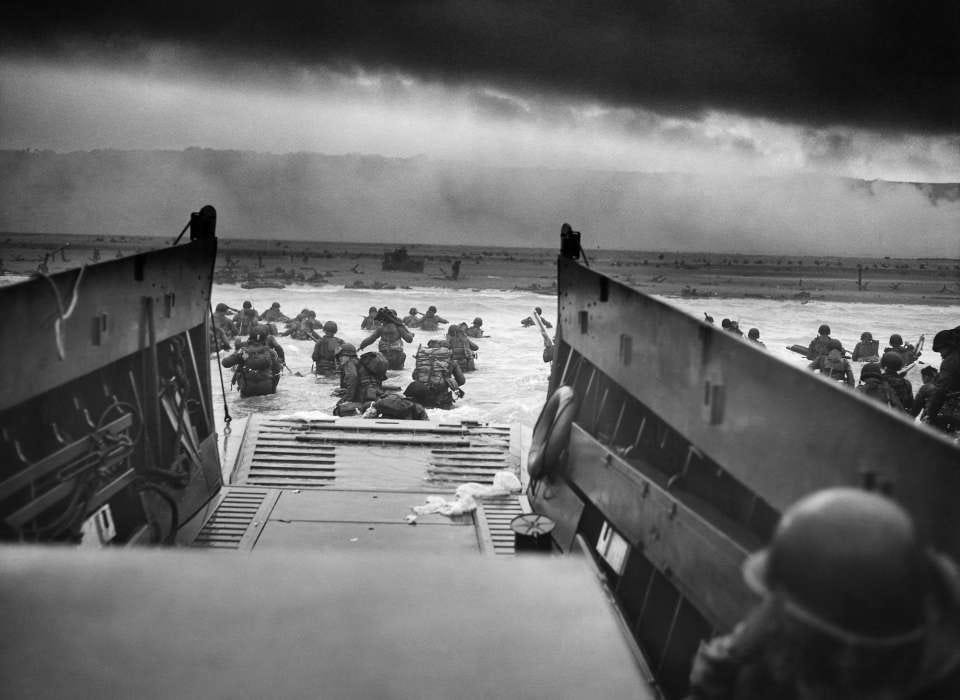 Image of U.S. Troops wading through water and Nazi gunfire on June 6, 1944.