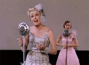 Debbie Reynolds and Jean Hagen starring in Singin' in the Rain. Hagen, playing Lina, is miming singing while Reynolds provides the voice.
