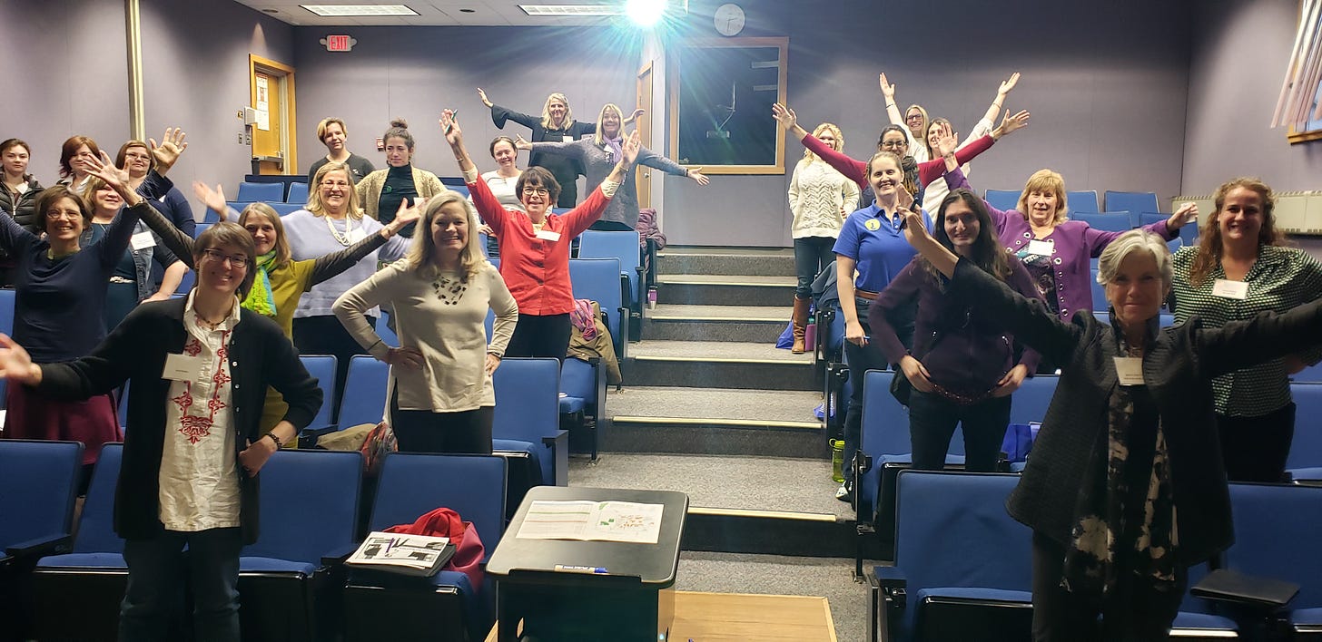 Women practicing power poses during a workshop on personal brand