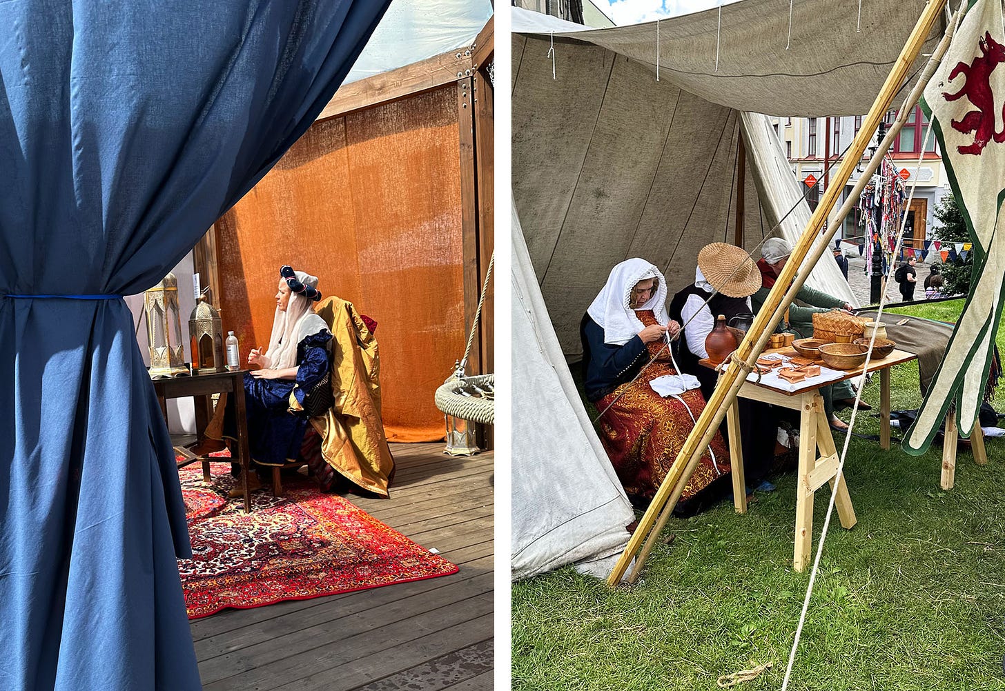 Two photographs showing women in traditional medieval dress in tents in the square of Tallin, Elstonia