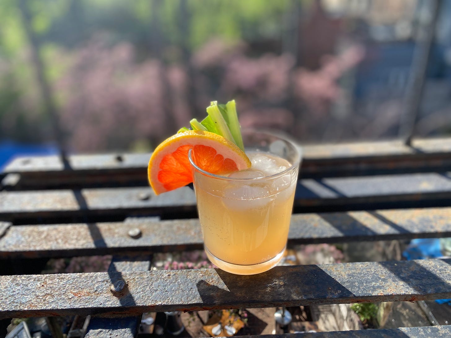 Rhubarb drink on fire escape grates with grapefruit garnish.