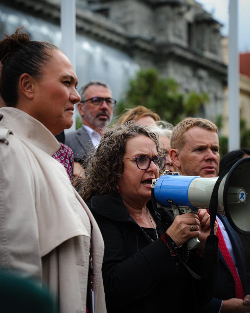 Jan Tinetti speaks on a loud hailer outside of parliament.