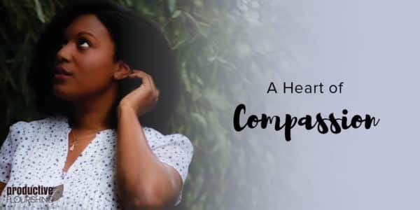 A woman with dark, short hair looks up at the right corner of the frame as she tucks her hair back. Text Overlay: A Heart Of Compassion