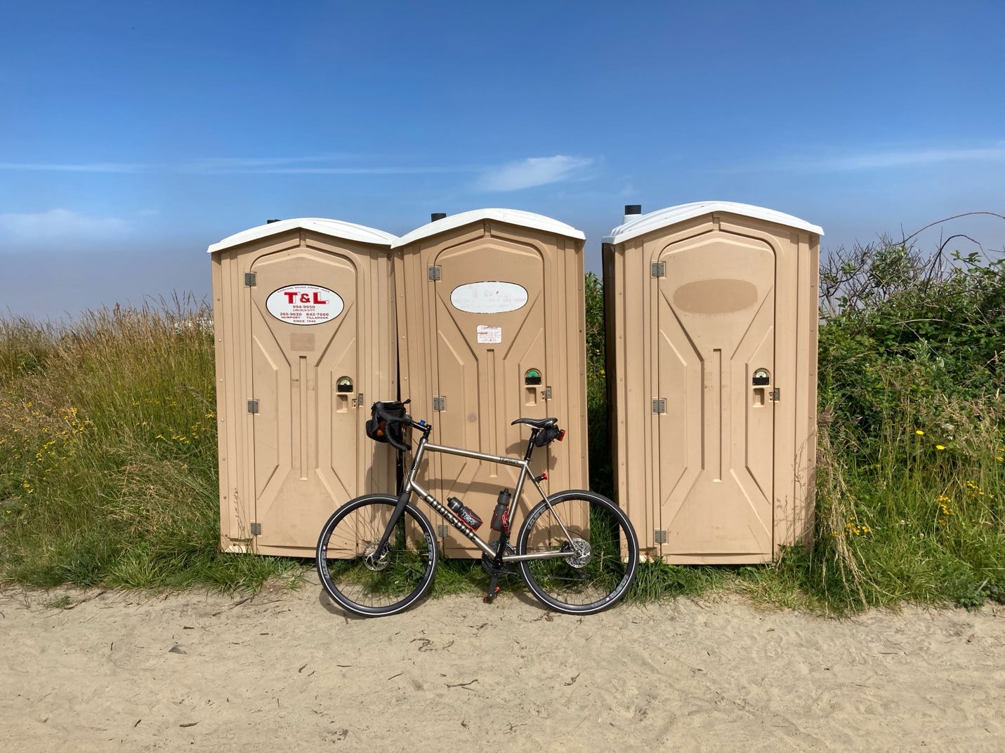 A bicycle leaning against a row of portable toilets

AI-generated content may be incorrect.