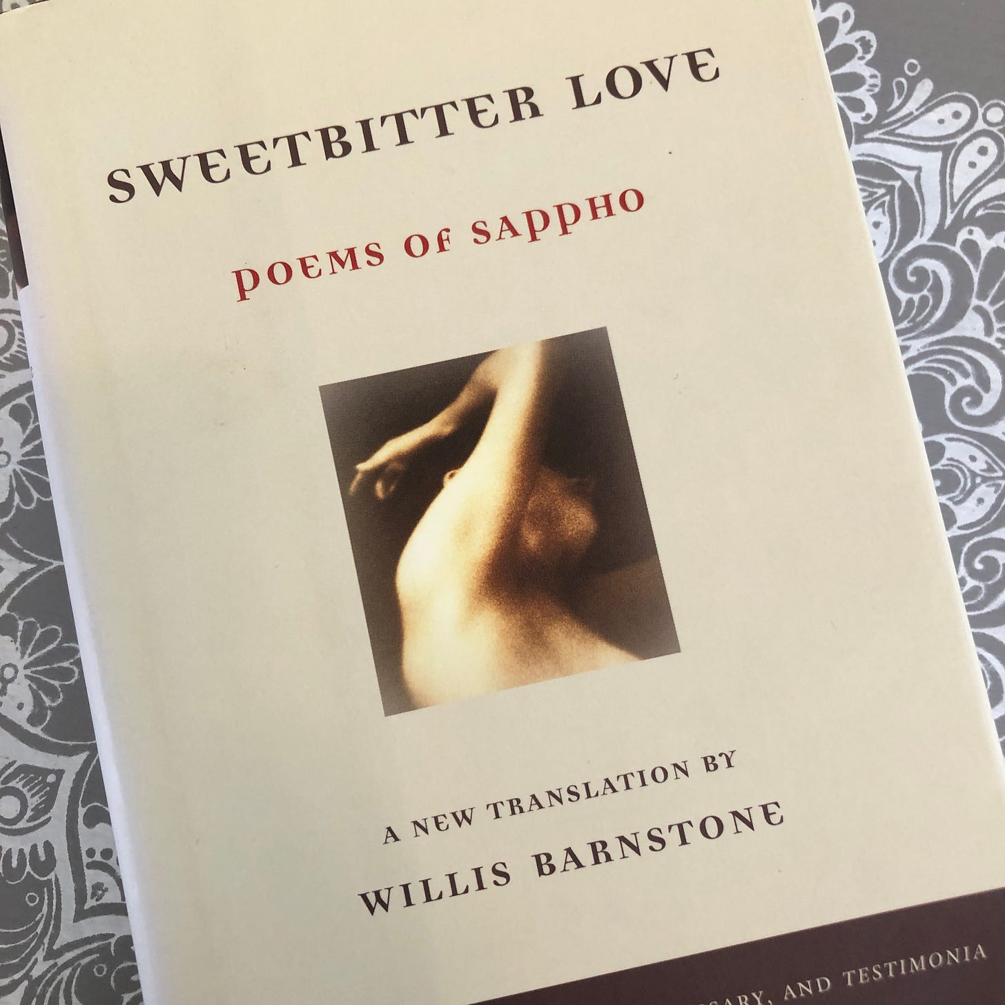 Bookcover with image of a nude figure’s arm and part of face and the words: “Sweetbitter Love/poems of Sappho” and “A new translation by Willis Barnstone.”