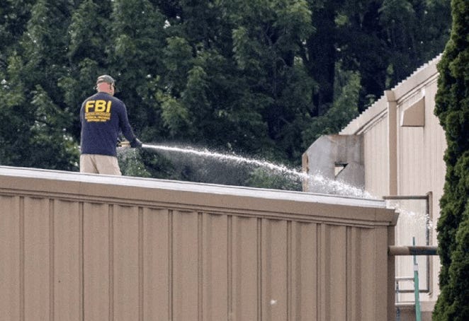 A person spraying water on a building

Description automatically generated