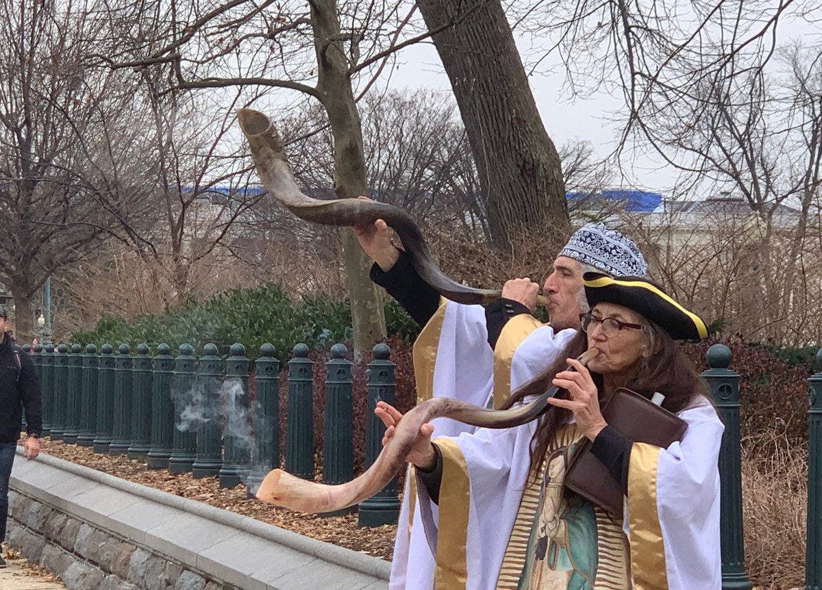 Two individuals from the Jericho March blowing smoke out of shofars
