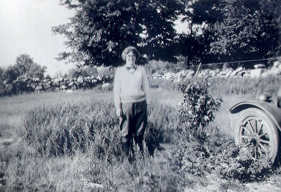 Woman in field next to Model T