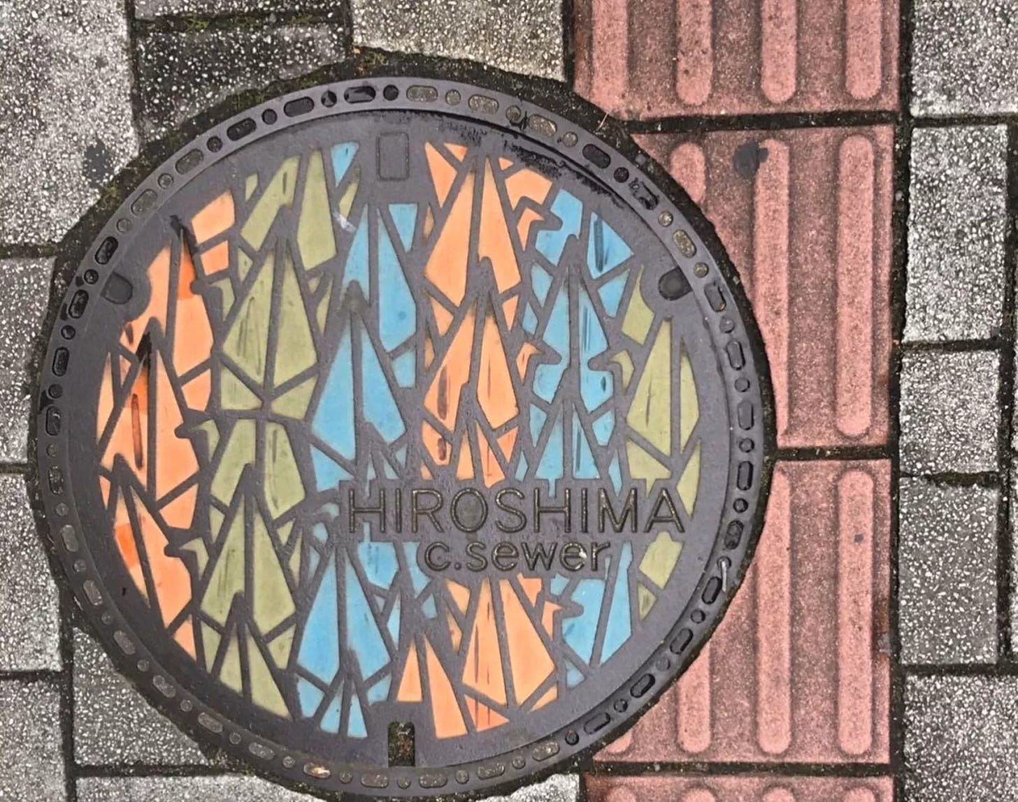 A decorative manhole cover in Hiroshima featuring an origami crane design.