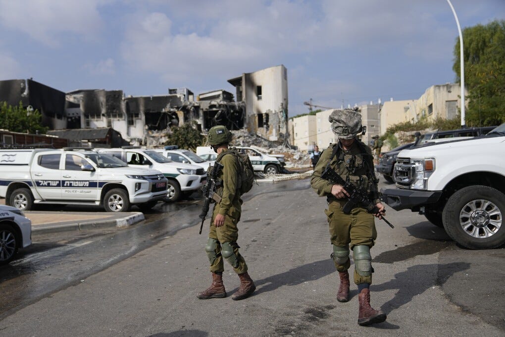 Israeli soldiers walk near the police station that was overrun by Hamas militants on Saturday, in Sderot, Israel, Sunday, Oct.8, 2023. Hamas militants stormed over the border fence Saturday, killing hundreds of Israelis in surrounding communities. (AP Photo/Ohad Zwigenberg)