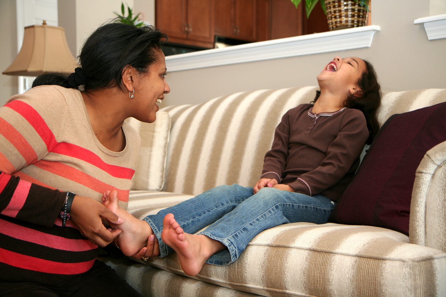 A parent tickling a child. 