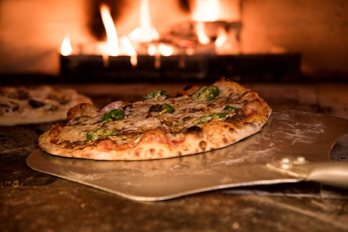 Free Baked Pizza on Pizza Peel in Oven Stock Photo