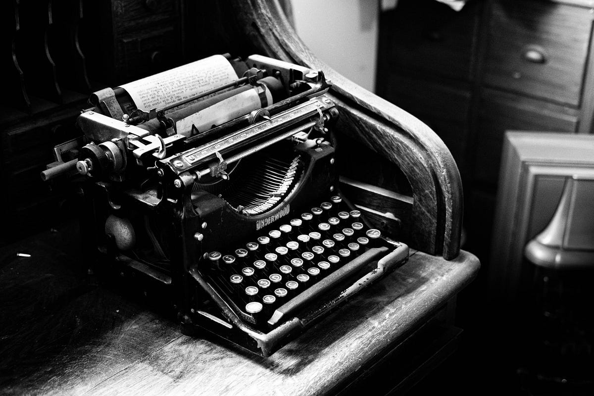 black and white picture of an antique typewriter on roll-top desk. Avoid common grammar errors